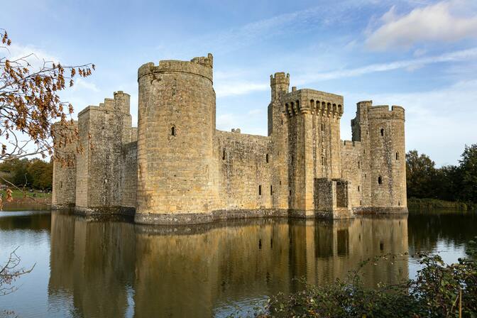 Castle in moat with peaceful water and calm sky